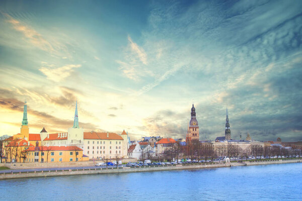 Beautiful view of the Riga Castle, St. Peter's Church and the tower of the Dome Cathedral on the banks of the Daugava River in Riga, Latvia