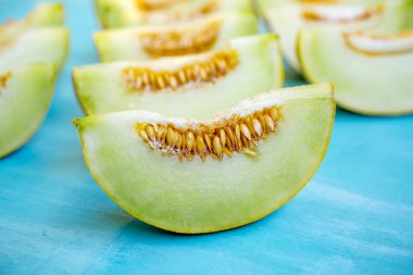 Mavi ahşap arka plan üzerinde kavun parçaları