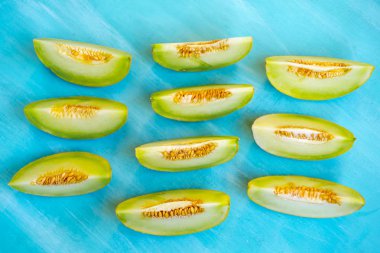 Mavi ahşap arka plan üzerinde kavun parçaları