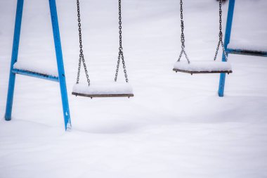 Kış. Çocuk salıncağı karla kaplı..