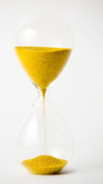 Beyaz arkaplanda altın boncuklu kum saati.