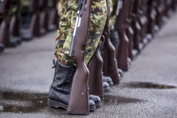 Soldiers stand in row. Gun in hand. Army, Military Boots lines of commando soldiers in camouflage uniforms