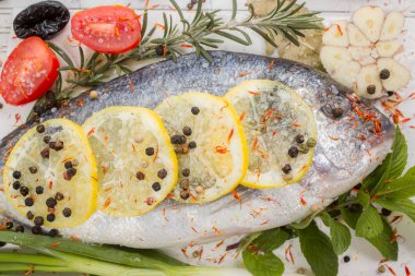 deniz levreği sebze ve baharat beyaz ahşap zemin üzerinde