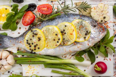 deniz levreği sebze ve baharat beyaz ahşap zemin üzerinde