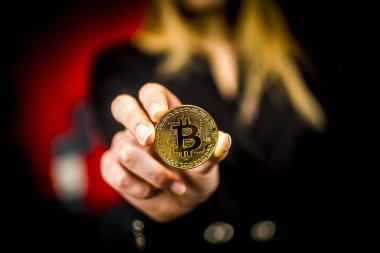 bir kadının elinde altın bitcoin
