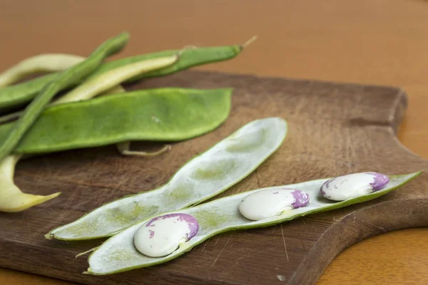 Garrofón crudo en primer plano, vainas de frijol en el fondo — Foto de Stock