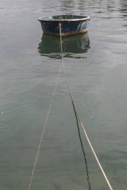 küçük tekne sakin suda bir halat ile demirli
