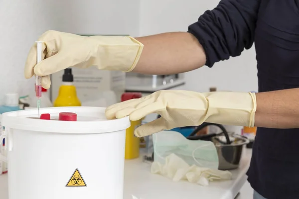 kova içinde kullanılan bir şırınga bırakarak için biyolojik risk olarak işaretlenmiş