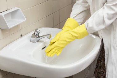 kişi üzerinde biohazard için muhtemelen sarı eldiven eldiven ellerini yıkama