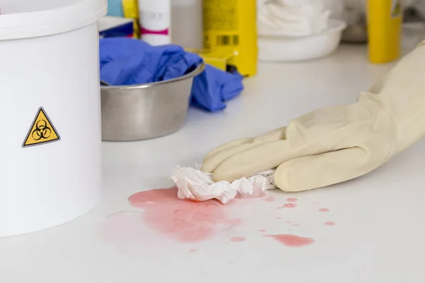 görüntünün köşesindeki bir pembe sıvı temizlik eldiveni ile biyolojik risk etiketli bir tekne el