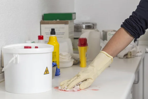 görüntünün köşesindeki bir pembe sıvı temizlik eldiveni ile biyolojik risk etiketli bir tekne el
