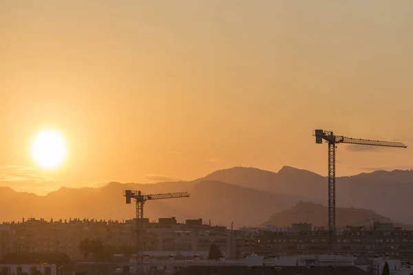 general view of Sagunto at sunset, highlighted construction cranes, Valencia, Spain