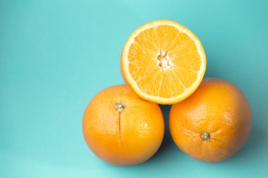Mavi arka planda iki portakal ve bir buçuk portakal görüntüsü