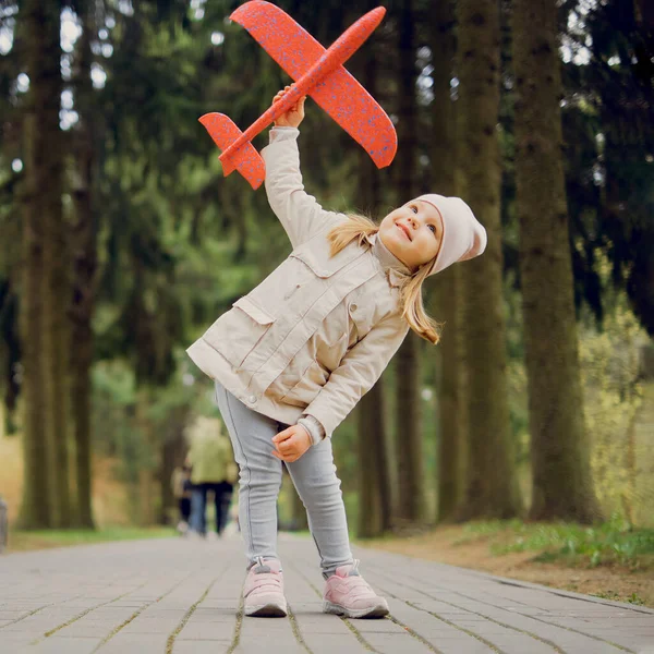 Portré 3 éves lány egy játék repülőgép a kezében a parkban — Stock Fotó