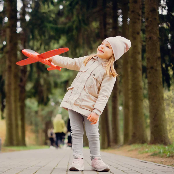 Portré 3 éves lány egy játék repülőgép a kezében a parkban — Stock Fotó