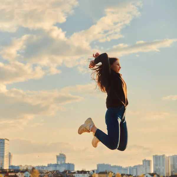 Portret młodej dziewczyny skaczącej na tle miasta — Zdjęcie stockowe