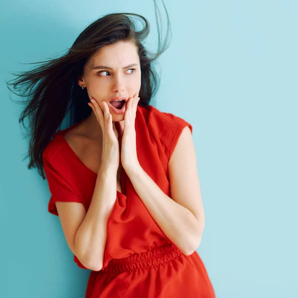 Retrato de estudio de una chica en un vestido rojo con sorpresa en su cara — Foto de Stock
