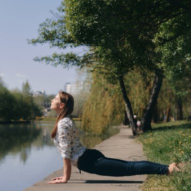 Kobralı kız parkta poz veriyor. sağlıklı yaşam tarzı konsepti. Yoga dışarıda