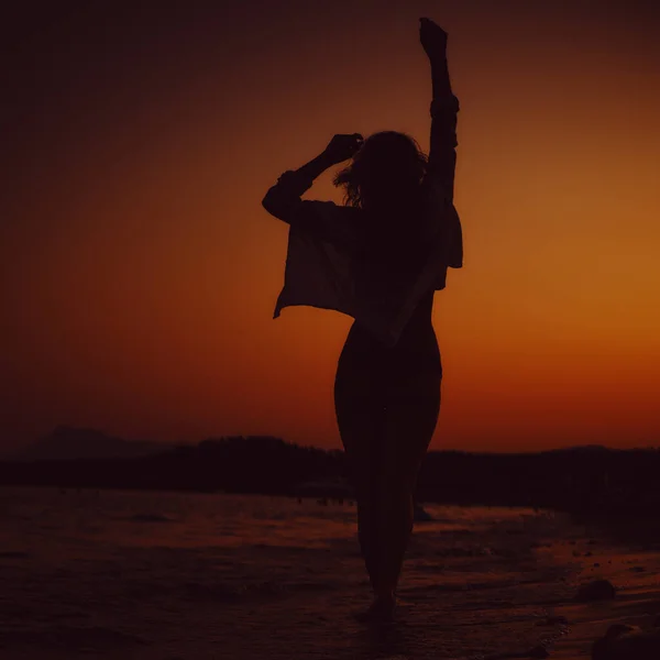 Silhouette d'une fille sur fond de coucher de soleil. voyage, concept de vacances — Photo