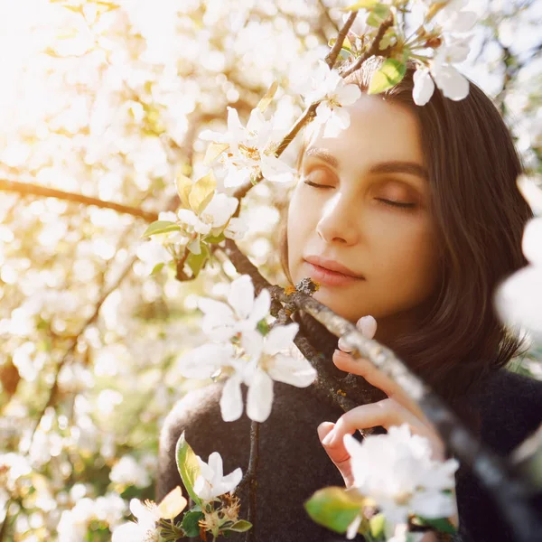 Porträt einer jungen Frau mit geschlossenen Augen in Apfelbäumen an einem sonnigen Tag. Dunkle Haare — Stockfoto