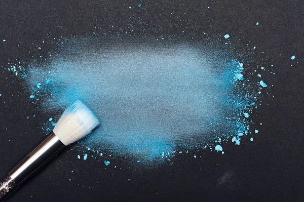 Cepillo de belleza y polvo de maquillaje azul manchado — Foto de Stock