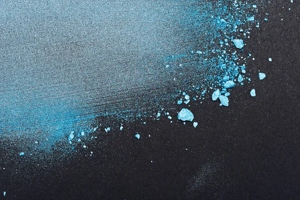 Partículas de polvo azul sobre papel negro — Foto de Stock