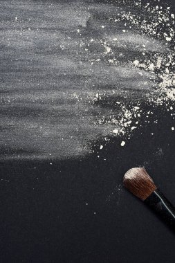 Dağınık beyaz yüz pudrası ve makyaj fırça