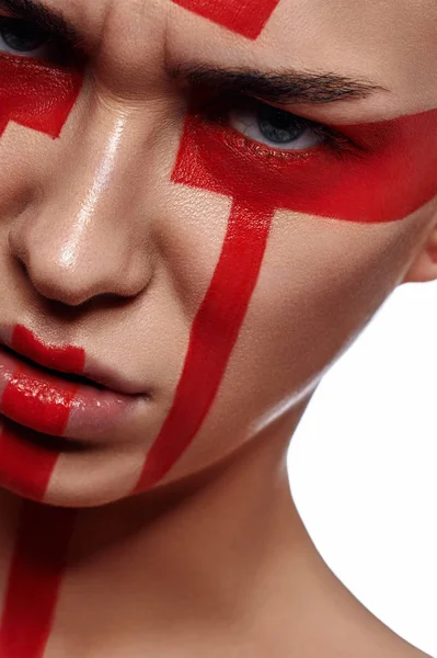 Mulher com formas pintadas de vermelho tribal em seu rosto — Fotografia de Stock