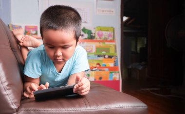 Asyalı çocuk çok hızlı akıllı telefon oynuyor.