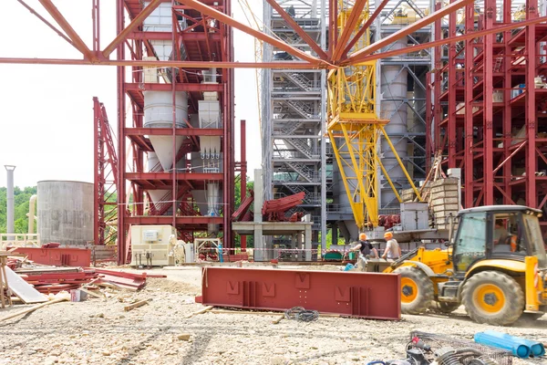 Industriebau. Arbeiter montieren den Bagger auf dem Bau einer Industrieanlage. Selektiver Fokus — Stockfoto