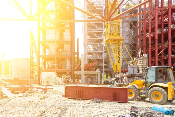 Construção Industrial. Trabalhadores montadores na escavadeira sobre a construção de uma instalação industrial. Imagem matizada. Foco seletivo — Fotografia de Stock