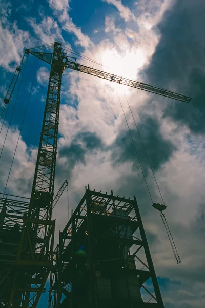 Silhouette of the crane against the sun, tinted photo — Stock Photo, Image