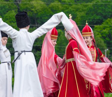 Çerkes etnik festivalin Adygeya Çerkezce kızlar ve erkekler için ulusal kostümleri dans