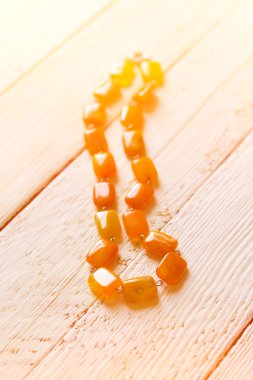 doğal yarı değerli taş akik boncuk Beyaz ahşap bir masa sığ derinlik-in tarla üzerinde güneş ışığı yanar