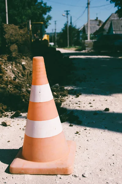 Obras de tierra en zonas rurales. advertencia cono de tráfico de cerca, foto teñida — Foto de Stock