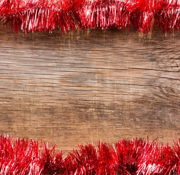 Old wooden boards framed by red tinselNew Year, Christmas background with space for text. Royalty Free Stock Photos