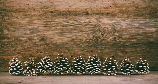 Fundo de madeira velho com cones de abeto. o conceito de um Natal de Ano Novo. foto matizado — Fotografia de Stock
