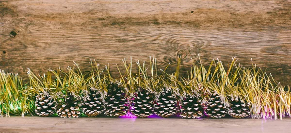 Fundo de madeira velho com cones de abeto, ouropel e guirlanda com espaço para texto. o conceito de Natal de Ano Novo. foto matizado — Fotografia de Stock