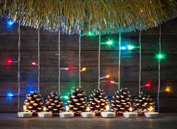 Εορταστικό Πρωτοχρονιάς και Χριστουγέννων έννοια. Πολύχρωμα φώτα γιρλάντες, ελάτου και κεριά για το ιστορικό της παλιές σανίδες αχυρώνα — Φωτογραφία Αρχείου