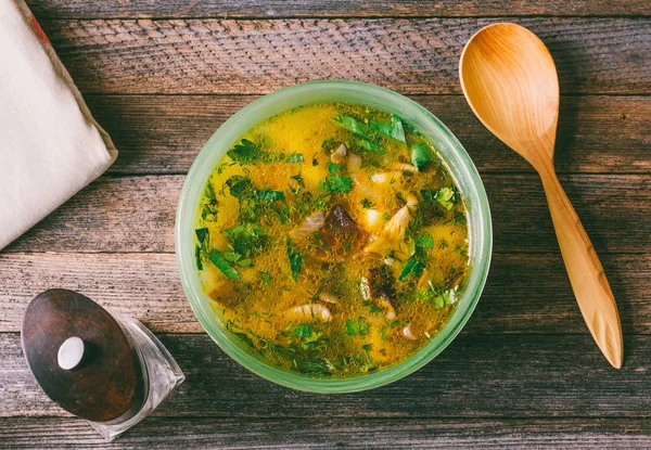 Sopa de champiñones con verduras, molino de pimienta y una cuchara de madera en la vieja mesa de madera de cerca, vista superior. foto teñida — Foto de Stock