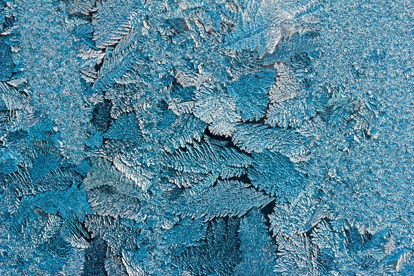 Textura abstrata de padrões de gelo azul em vidro de perto, foto matizada — Fotografia de Stock