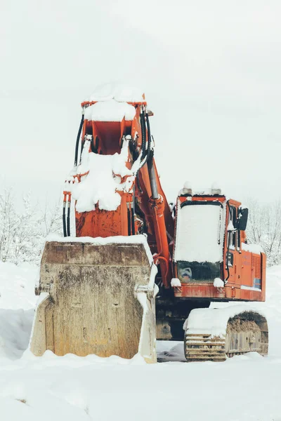 Excavadora de pie en la nieve invierno al aire libre, de cerca. El concepto de desempleo, el fracaso de — Foto de Stock