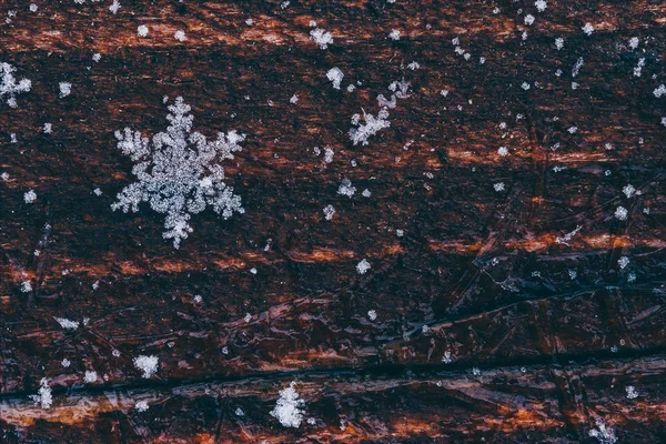 Fiocco di neve naturale su sfondo marrone in legno con spazio per il testo. foto colorata — Foto Stock