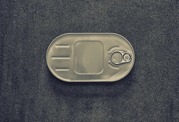 Canned closed in an oval box on a gray background, view from above — Stock Photo, Image