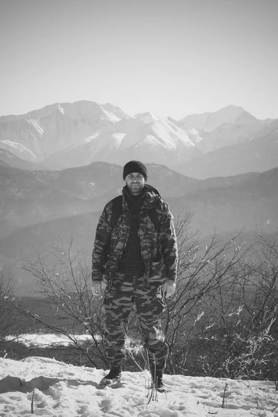 Viajero masculino de mediana edad sobre un fondo de montañas en el invierno, una foto en blanco y negro —  Fotos de Stock