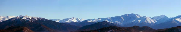 Panoramic photo of the mountain peaks a Sunny winter day — Stock Photo, Image