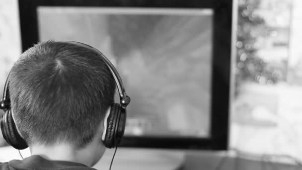 Imágenes en blanco y negro chico caucásico en los auriculares jugando el juego de ordenador. el concepto de adicción al juego, adicción a la computadora. enfoque selectivo — Vídeos de Stock