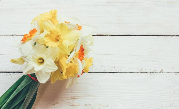 新鮮な花水仙クローズ アップ トップ ビューのテキストのためのスペースと白い木製の背景の花束 — ストック写真
