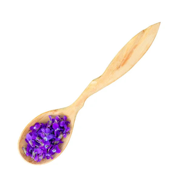 Delicados pétalos de flores violetas en una cuchara de madera aislada sobre fondo blanco — Foto de Stock