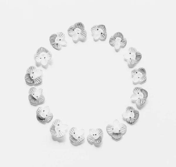Marco redondo vintage de pequeñas flores sobre un fondo blanco con espacio para texto, foto en blanco y negro. Piso tendido, vista superior —  Fotos de Stock